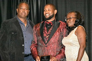 Pine Bluff High School football Coach Micheal Williams receives an award from Ben Redix, father of Benjamen Redix, and Shaneisha Robinson, Benjamen Redix's mother, during the first Benjamen Redix Project Gala at the White Hall Community Center on Saturday, April 13, 2024. (Pine Bluff Commercial/I.C. Murrell)